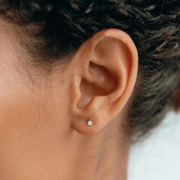 Close-up of a 14k White Gold Diamond Stud Earrings 2mm - Aria worn on ear with soft natural lighting