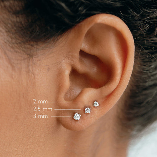 Close-up of ear wearing 14k White Gold Diamond Stud Earrings 2mm - Aria with 2.5mm and 3mm sizes on white background