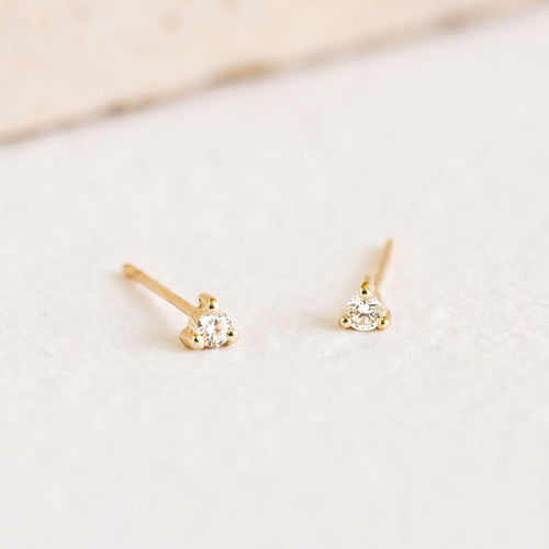 Close-up of 14k Yellow Gold Diamond Stud Earrings 2mm - Aria with lab grown diamonds on a soft white surface