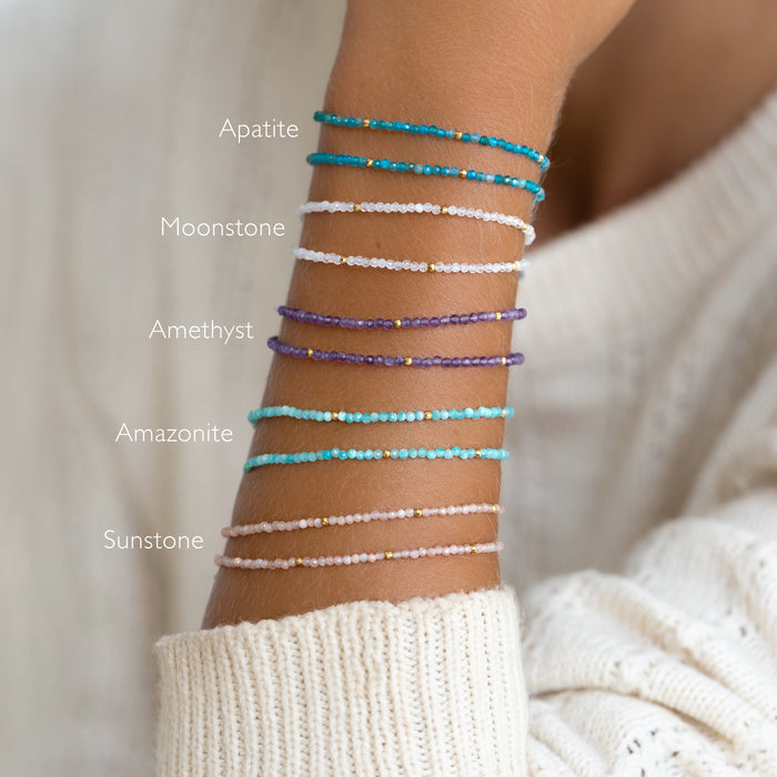 Close-up of a wrist wearing layered Apatite Bracelet and other gemstone beaded bracelets with gold vermeil accents