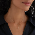 Close-up of woman wearing April Birthstone Pendant 14k Gold - White Topaz with black collared shirt on neutral background