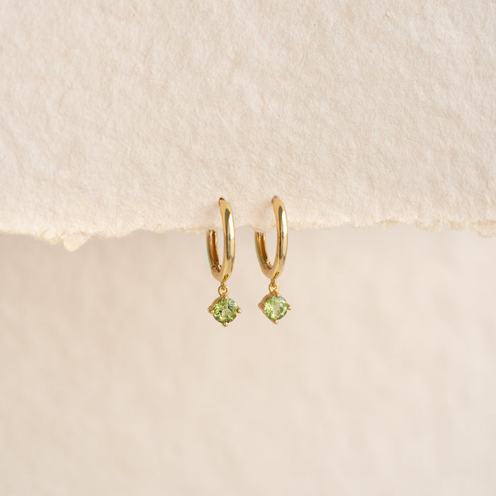 August Birthstone Drop Huggie Earrings - Peridot with gold vermeil hoops and green peridot gemstones on neutral background