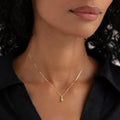 Close-up of woman wearing August Birthstone Pendant 14k Gold - Olivine on a delicate gold chain with black top