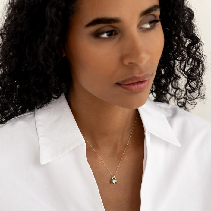 Close-up of woman wearing August Birthstone Pendant 14k Gold - Olivine styled with a white collared shirt