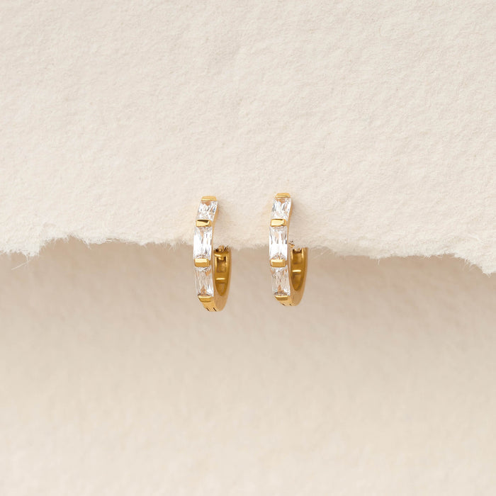 Pair of Gold Vermeil earrings set with baguette-cut gemstone, displayed hanging against a soft, textured ivory background.