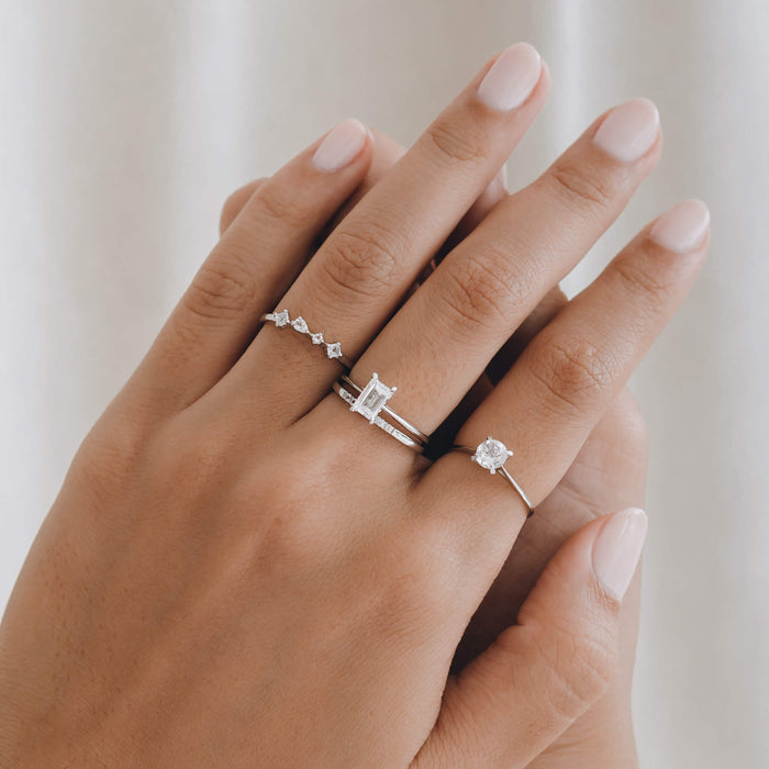Stack of white topaz silver rings on model