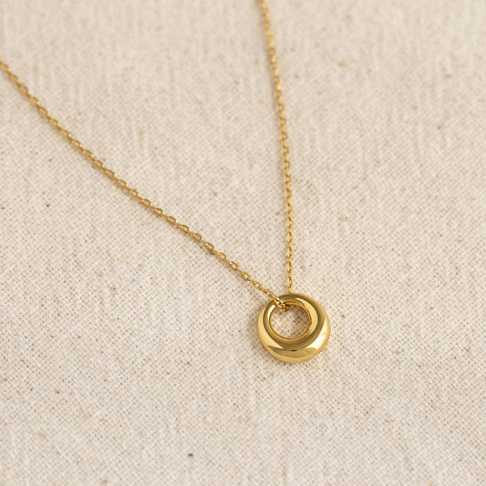 Close-up of a gold vermeil tapered circle pendant on a dainty cable chain from the Circle Pendant Necklace - Lilou collection