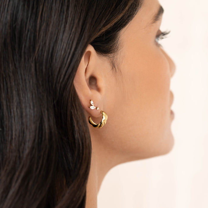 Close-up of a woman wearing Croissant Earrings - Piper in gold vermeil with butterfly back closure against a neutral background