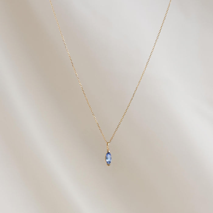 December Birthstone Pendant 14k Gold - Tanzanite marquise-cut gemstone on a delicate gold chain against a soft background