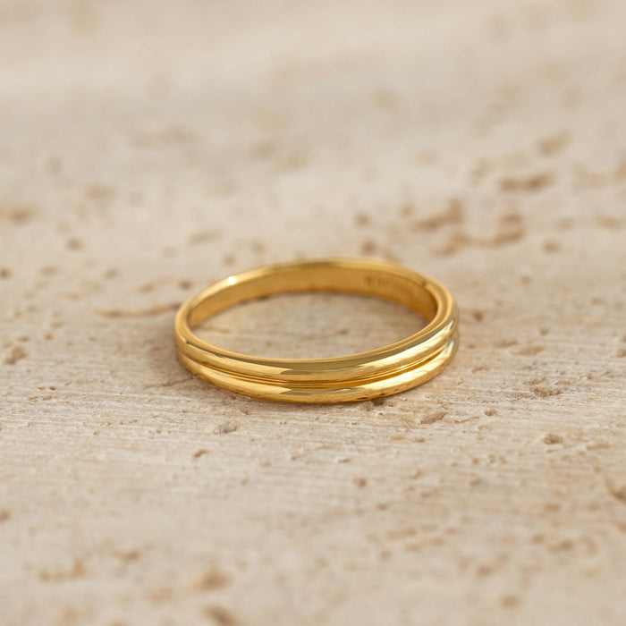 Close-up of a gold vermeil Double Stacking Ring - Idalia with a ribbed double band design on a textured surface