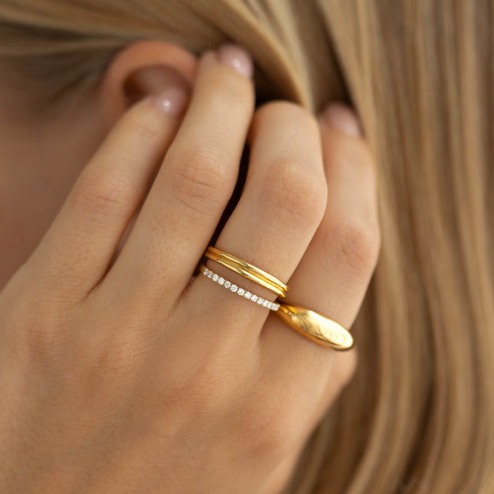 Close-up of a hand wearing the Double Stacking Ring - Idalia in gold vermeil beside a delicate diamond band
