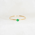 Emerald Ring 14k Gold - Penelope featuring a round lab grown emerald set on a delicate hammered gold band on white background
