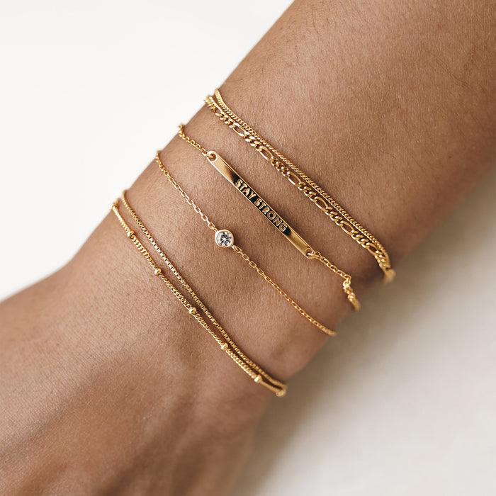 White topaz gemstone bracelet stacked with gold chains