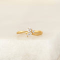 Delicate Gold Vermeil ring featuring a cluster of mixed-cut gemstone, including pear, round, and baguette shapes, set on a slim band and displayed on a soft neutral surface.