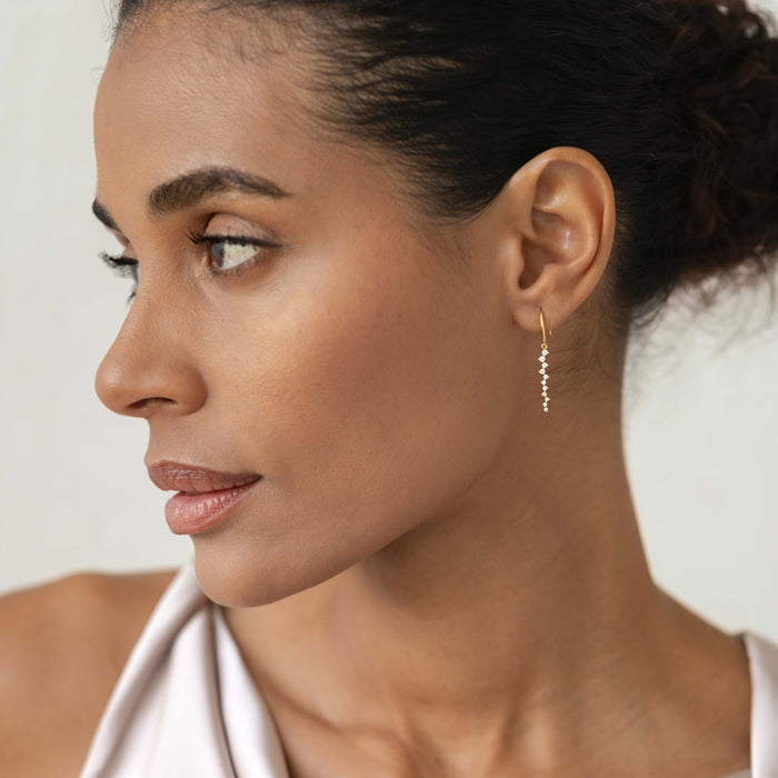 Profile of a woman wearing Gemstone Drop Earrings - Tamara featuring graduated cubic zirconia stones set in gold vermeil