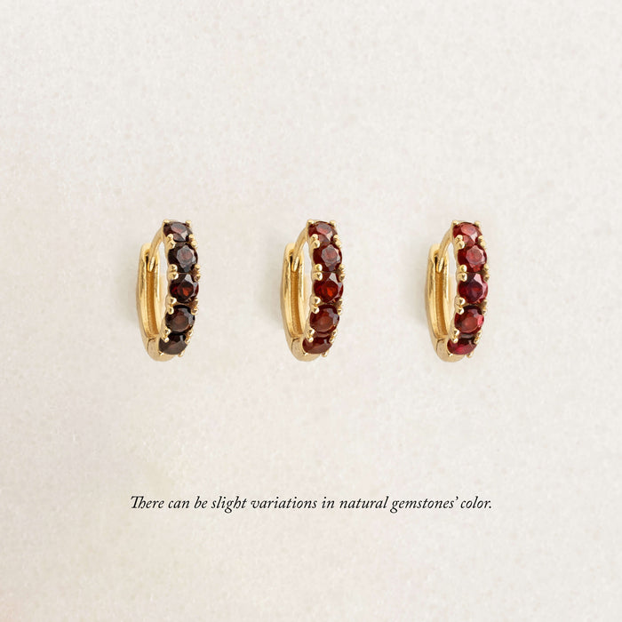Three Gold hoop earrings, each set with garnet gemstones, set in gold vermeil. Arranged in a row on a light background.