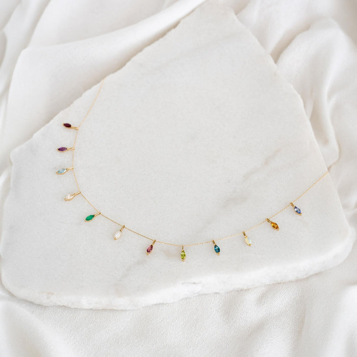 January Birthstone Pendant 14k Gold - Garnet displayed among various colorful marquise-cut gemstone charms on a white background