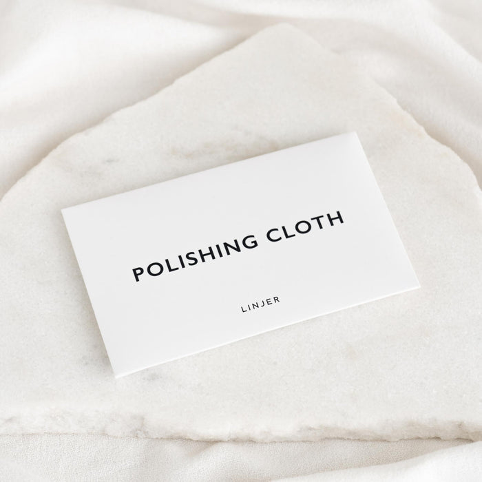 Jewelry Polishing Cloth packaging displayed on a white marble surface with soft natural lighting