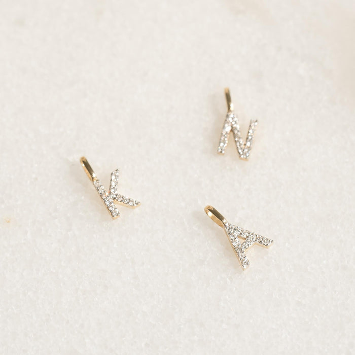 Three diamond initial pendant 14k gold charms in letters K, N, and A displayed on a light background