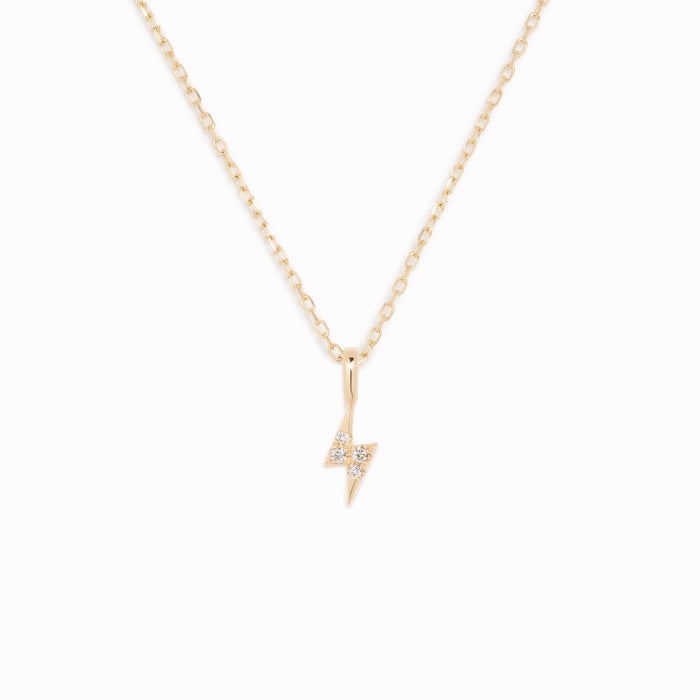Diamond Lightning Bolt Charm 14k Gold with round diamonds on a delicate yellow gold chain on a white background