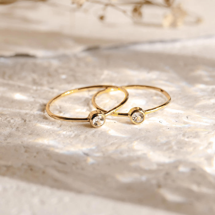 Two 14k gold bezel-set diamond rings