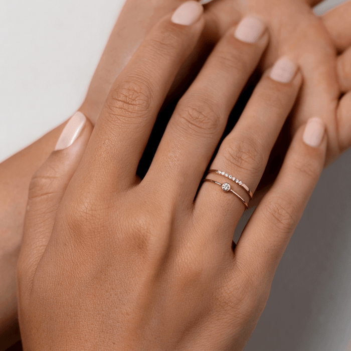 Bezel-set diamond ring on 14k gold band with diamond pave yellow gold band