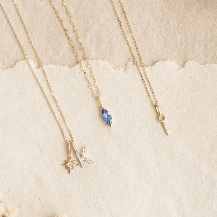 Diamond Star Charm 14k Gold pendant with round diamond on a delicate gold chain displayed on a neutral background