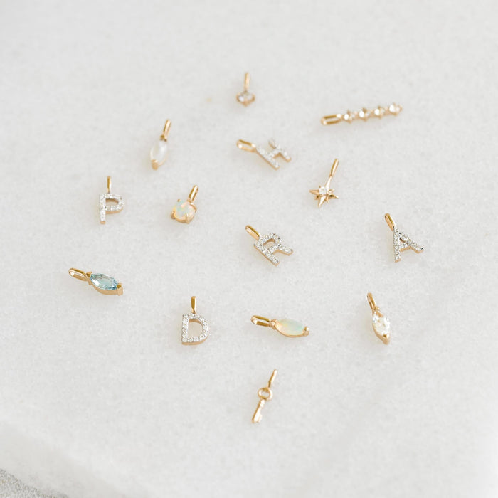 Diamond Star Charm 14k Gold among delicate 14k gold letter and gemstone charms on a soft neutral background