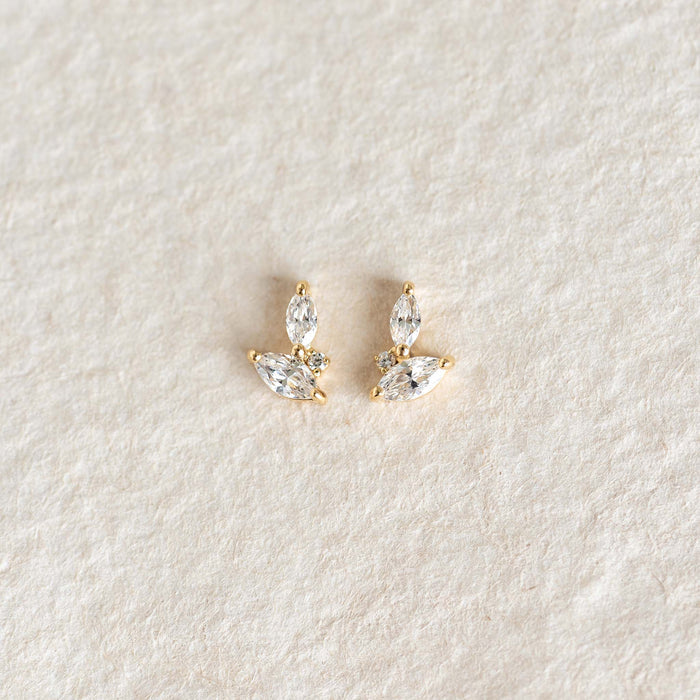 Pair of delicate Leaf Earrings - Selma with cubic zirconia leaf design on a soft neutral fabric background