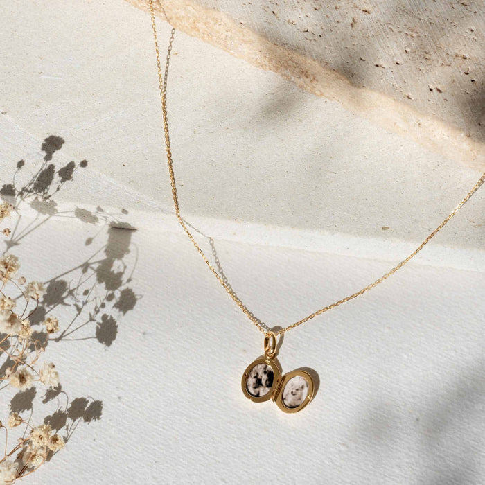 Locket Necklace Silver - Marte with a delicate open silver locket pendant on a long thin chain against a neutral background