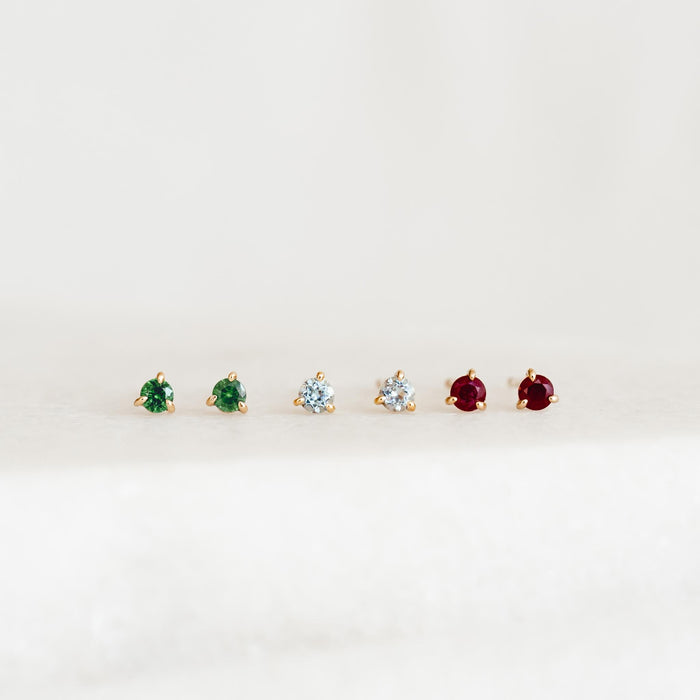 March Birthstone Stud Earrings 14k Gold - Blue Topaz with green and red gemstone pairs on a neutral background