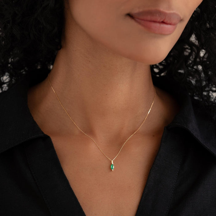 Close-up of a woman wearing the May Birthstone Pendant 14k Gold - Green Agate with a black collared shirt