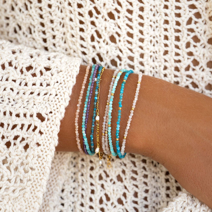 Close-up of an arm wearing the Multi Strand Beaded Bracelet with amethyst, amazonite, sunstone, and apatite crystals