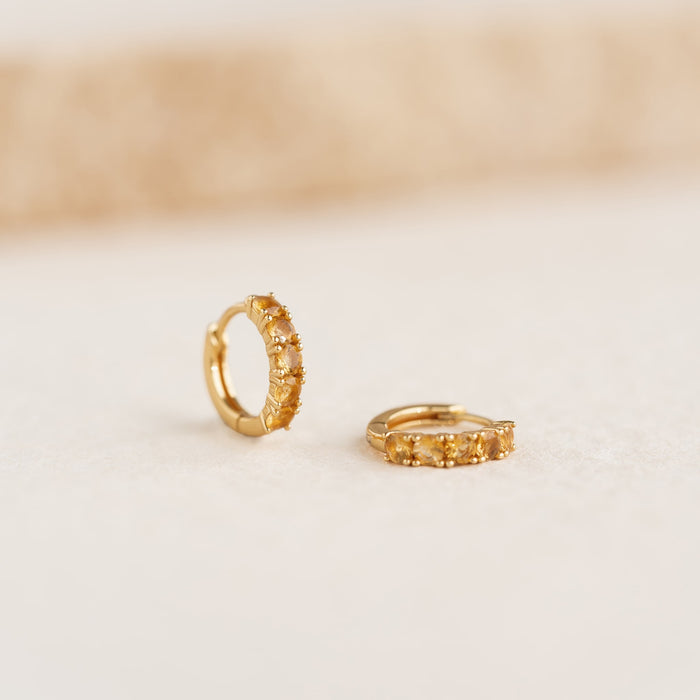 November Birthstone Huggie Earrings - Citrine featuring gold vermeil hoops with vibrant citrine gemstones on a soft background
