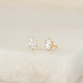 A pair of oval-cut gemstone stud earrings set in Gold Vermeil, displayed on a soft neutral surface with a minimal, elegant background.