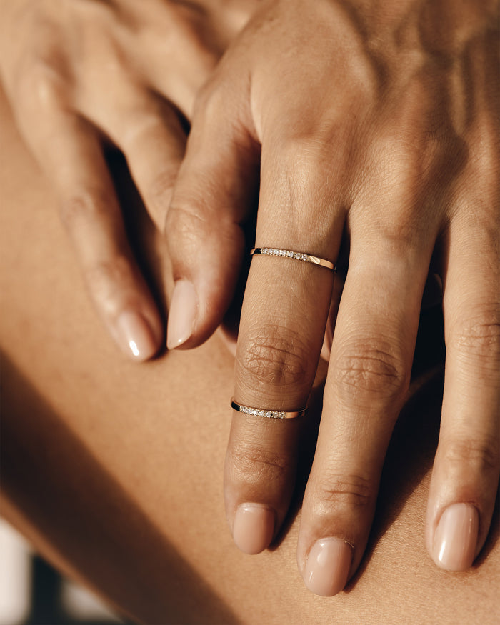 Two gold vermeil pave gemstone rings with white topaz stacked on hand