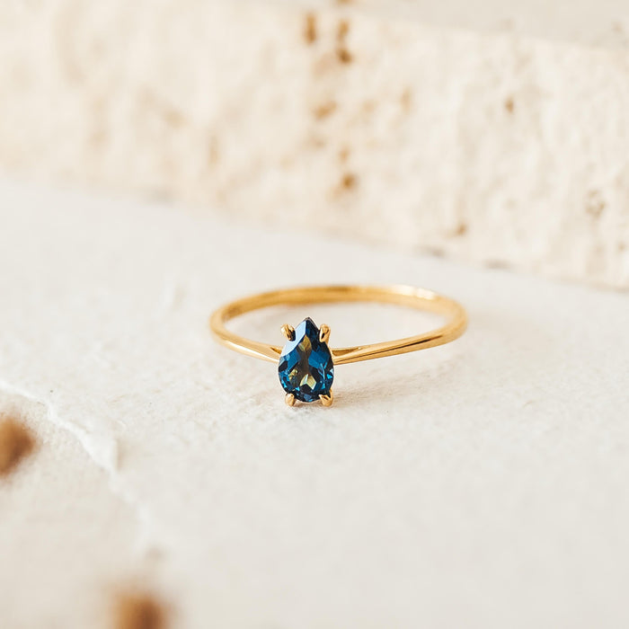 Pear shaped london blue topaz solitaire ring on gold band