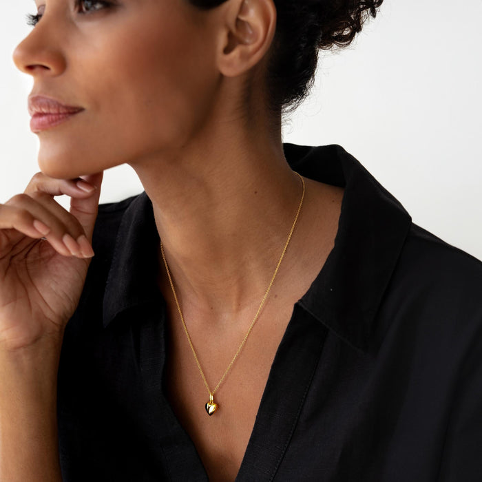 Heart pendant on a delicate gold chain on model