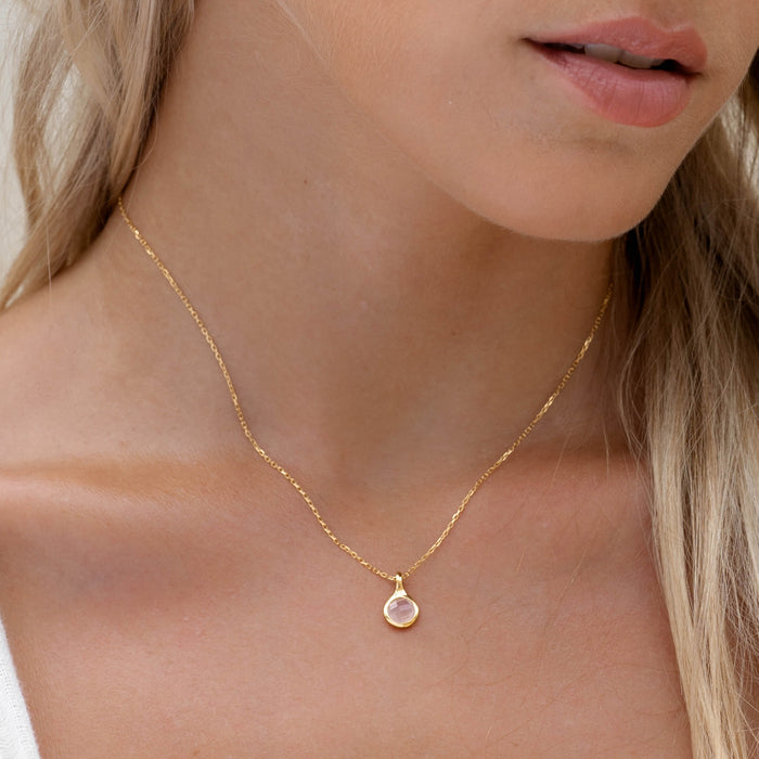 Close-up of woman wearing Rose Quartz Necklace - Sigrid with a hand-cut pink gemstone on a delicate gold chain