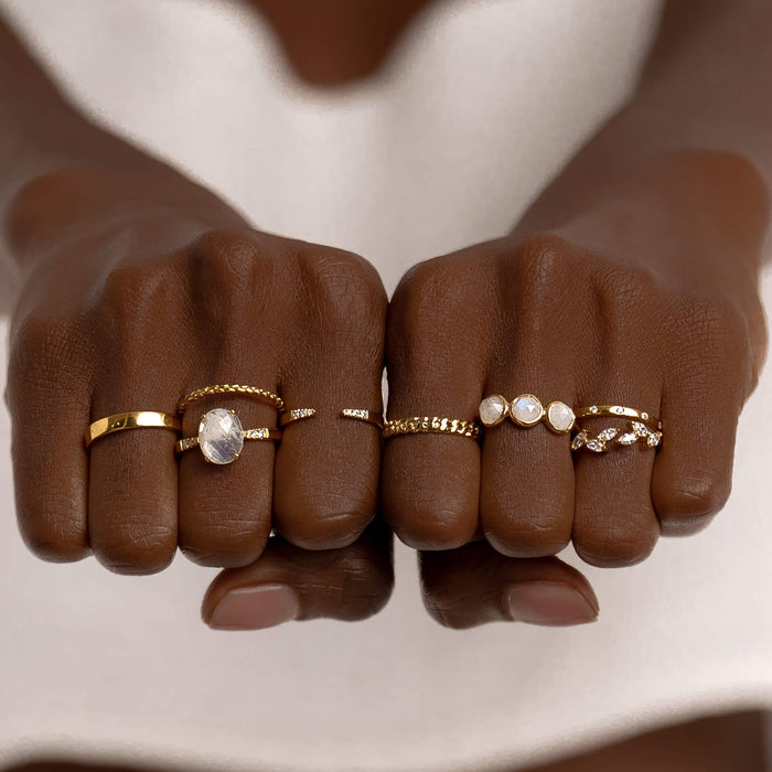 Gold vermeil stacking rings with diamonds and gemstones on model’s hand