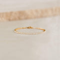 Close-up of the Tennis Bracelet - Audrey featuring sparkling cubic zirconia stones set in gold vermeil on a neutral surface