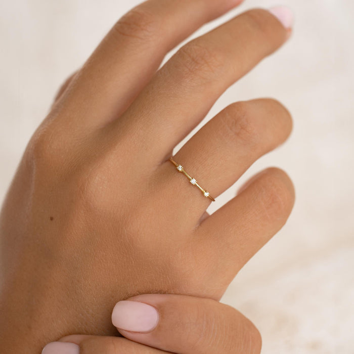 Three Stone Diamond Ring 14k Gold - Estelle worn on a hand with soft pink nail polish on a neutral background