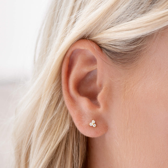 Flower shaped stud earrings with white gemstones in gold