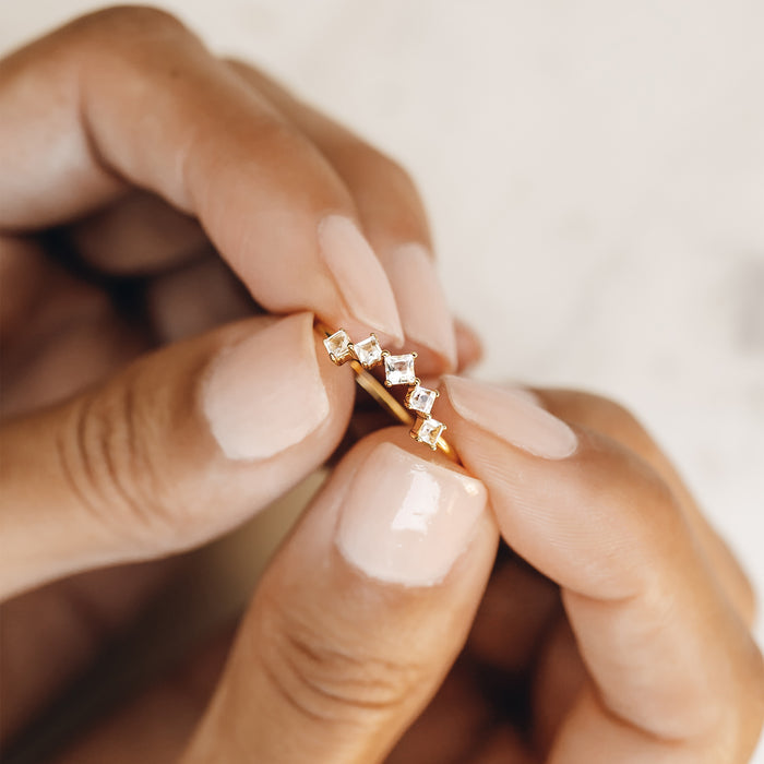 Gold curved band with white topaz gemstones