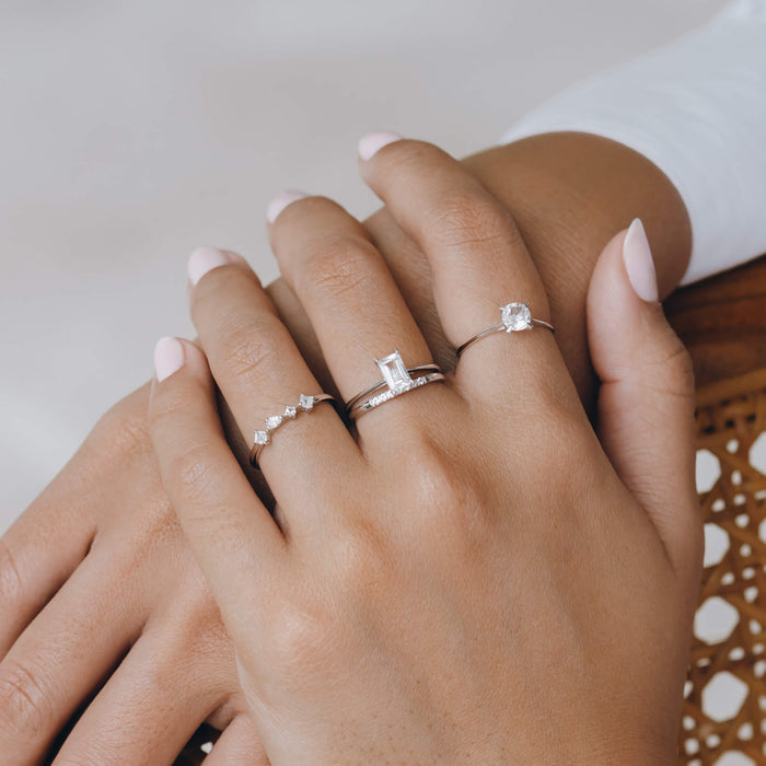 White gemstone stack of silver rings on model