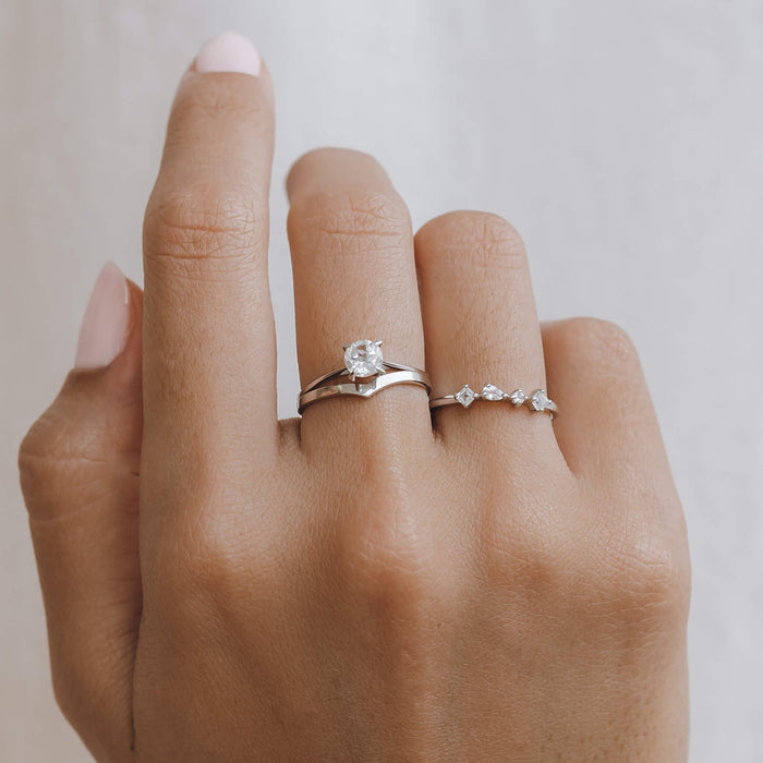 Silver ring with four delicate white topaz gemstones stacked on model