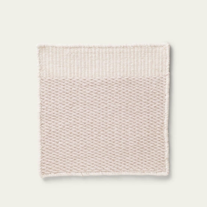 Beige textured rug on a light gray background, #dunegray