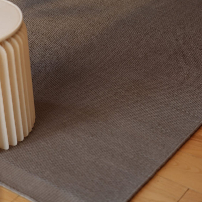 Slate Gray wool rug on a wooden floor with a beige cylindrical object to the  left. #slategray